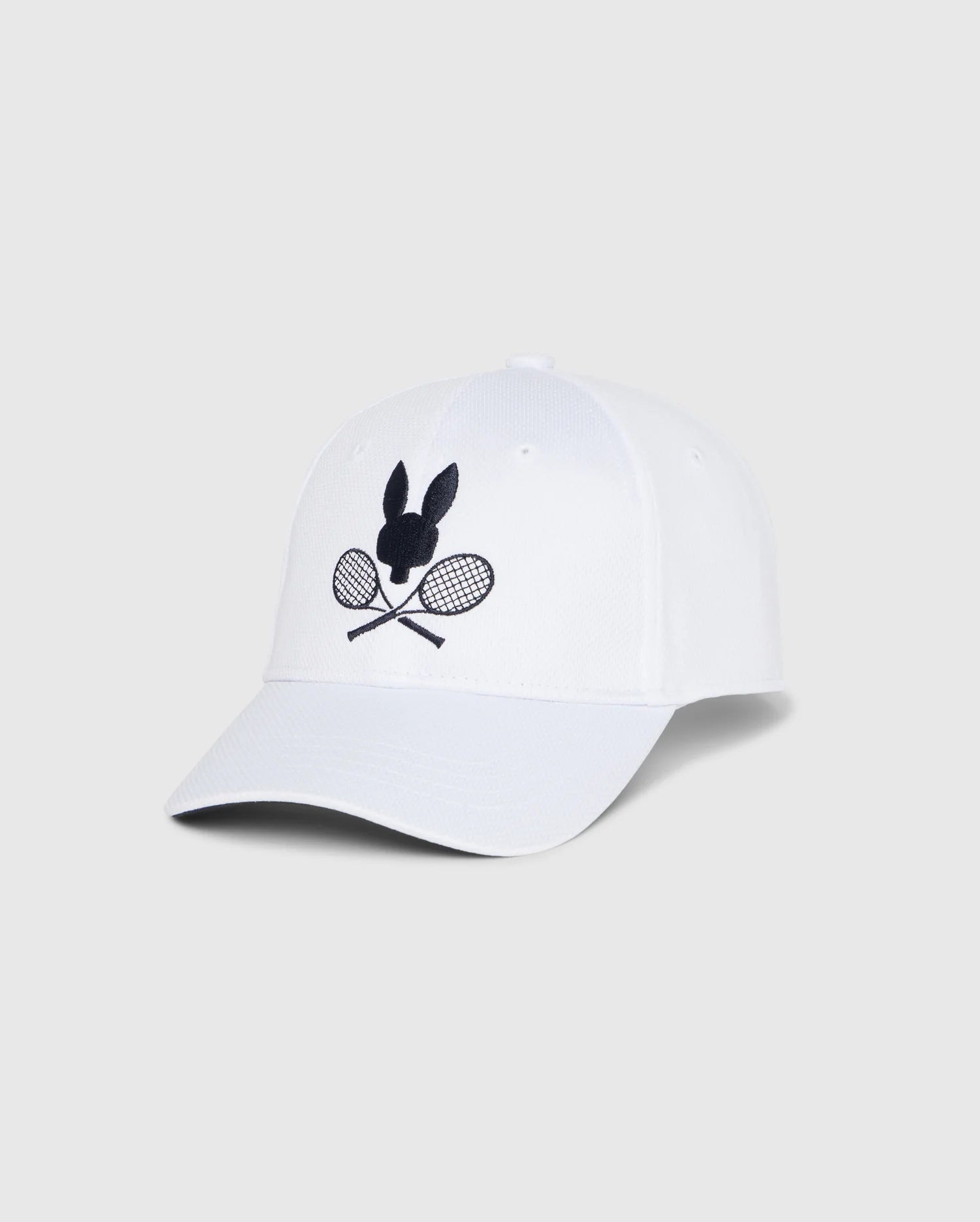 The Psycho Bunny KIDS COURTSIDE SPORT CAP in white, with an embroidered black bunny silhouette above crossed tennis rackets, makes a perfect tennis-inspired staple. Displayed against a plain light gray background. Model: B0A685C200.