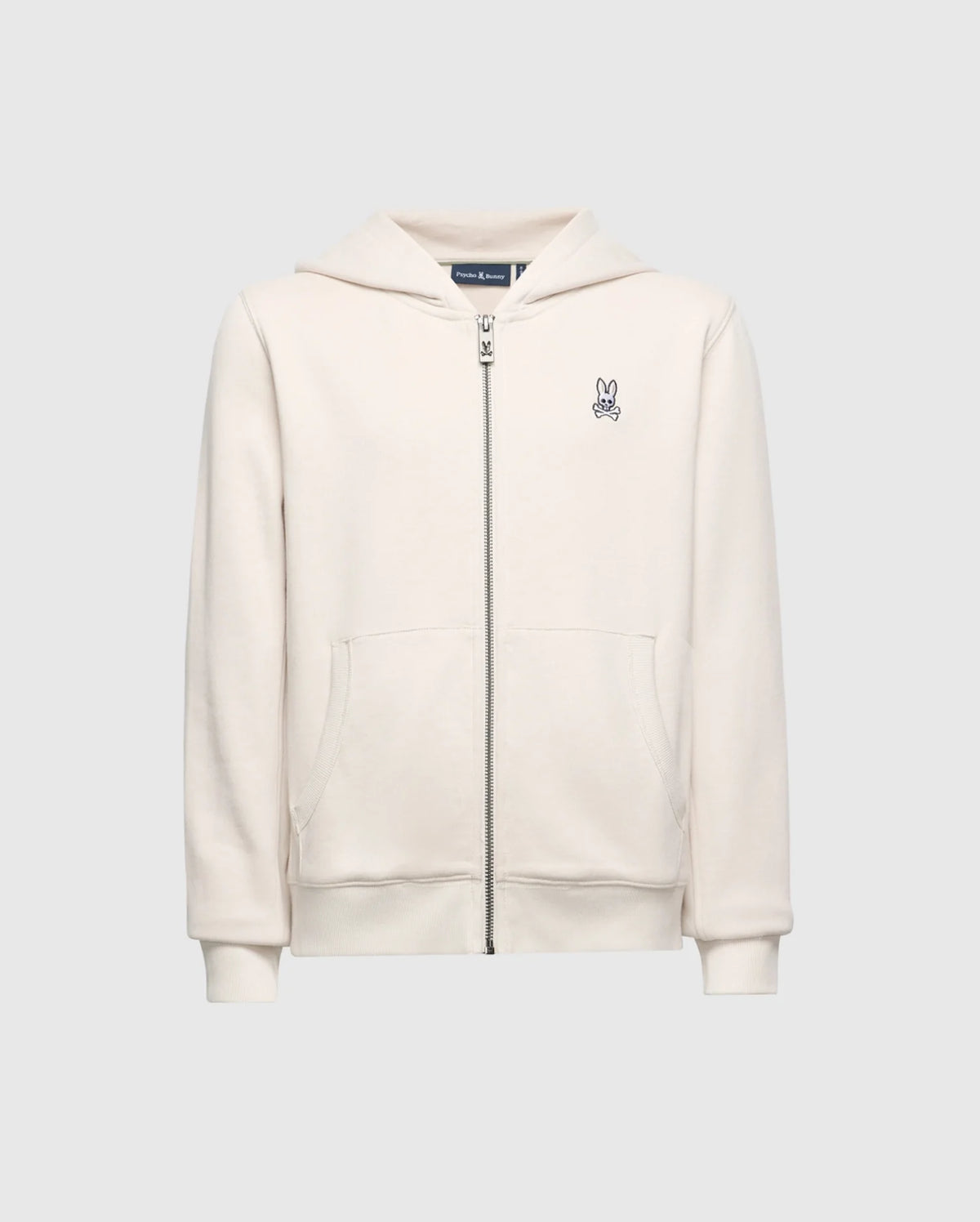 The Psycho Bunny KIDS LEVY ESSENTIAL ZIP FLEECE HOODIE (B0H720D200) in cream features a soft French terry fabric, front zipper, two pockets, and a small embroidered peace sign on the left chest. Displayed against a plain gray backdrop, this cotton hoodie ensures style and comfort.