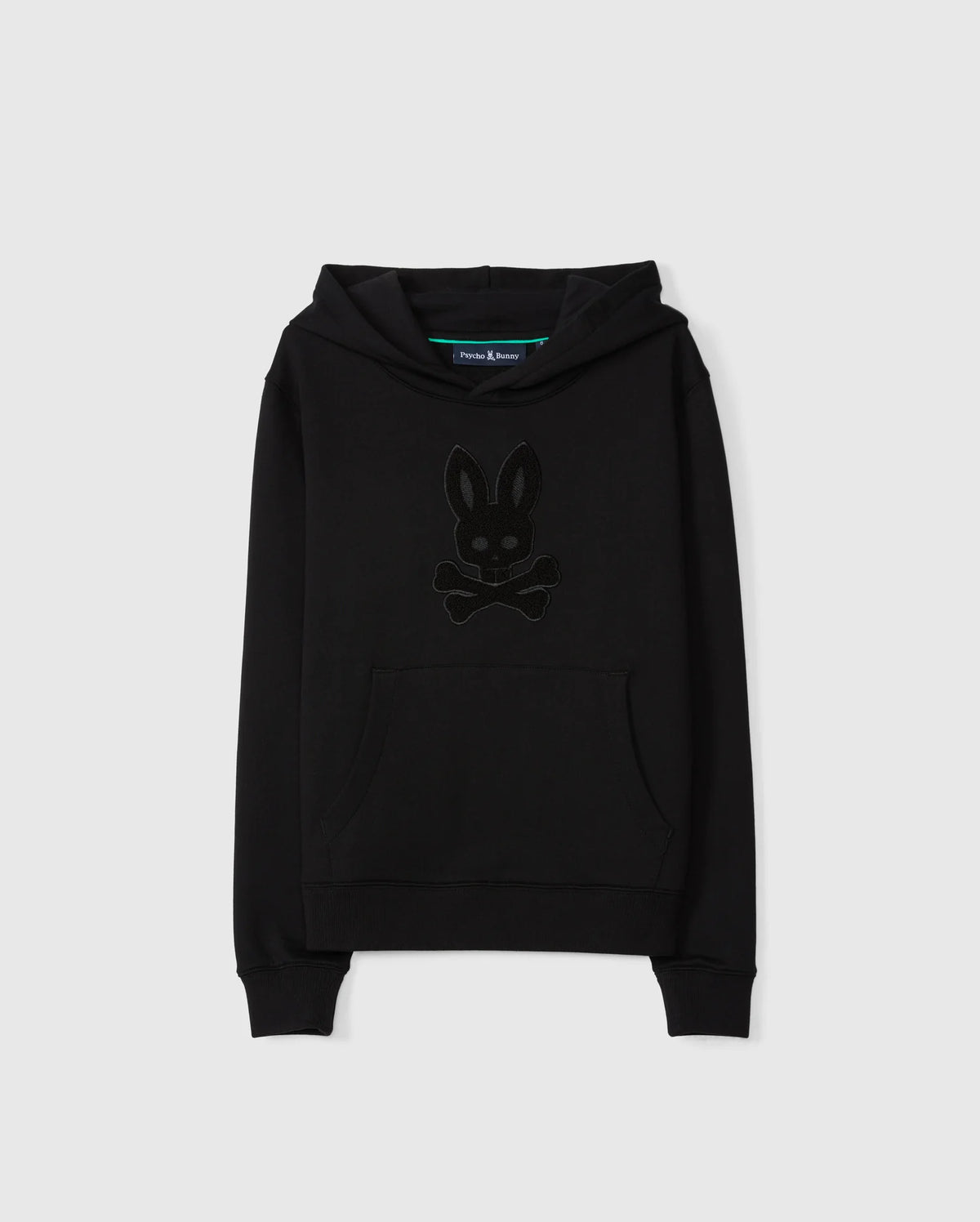 Introducing the KIDS PACIFIC CHENILLE HOODIE - B0H930D200 by Psycho Bunny, a black pullover hoodie made from soft French terry. It features a front pocket and hood with a distinctive dark-toned logo design resembling a bunny head with crossbones underneath, stunningly contrasted against a plain white background.