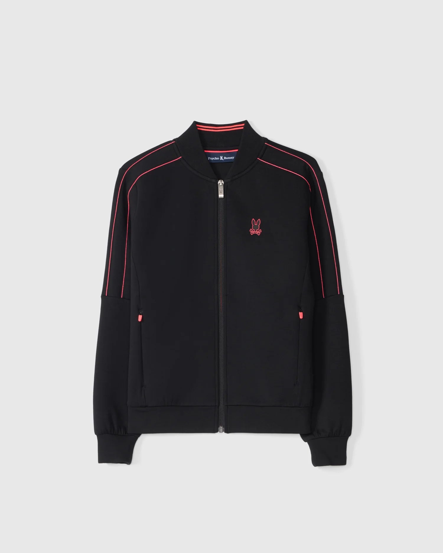 The KIDS TRAVIS TRACK JACKET - B0J142D200 by Psycho Bunny is a black regular-fit jacket featuring striking red piping along the sleeves and shoulders. This high-quality cotton-blend piece includes a distinct red embroidered rabbit logo on the left chest, two convenient pockets, and ribbed cuffs and hem, all displayed against a plain white background.
