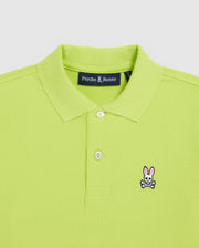 The Psycho Bunny Kids Classic Polo (B0K001CRPC) in lime green features a fold-over collar, two buttons, and a chest embroidery of a bunny with crossbones. Made from Pima cotton for quality, it offers a regular fit design.