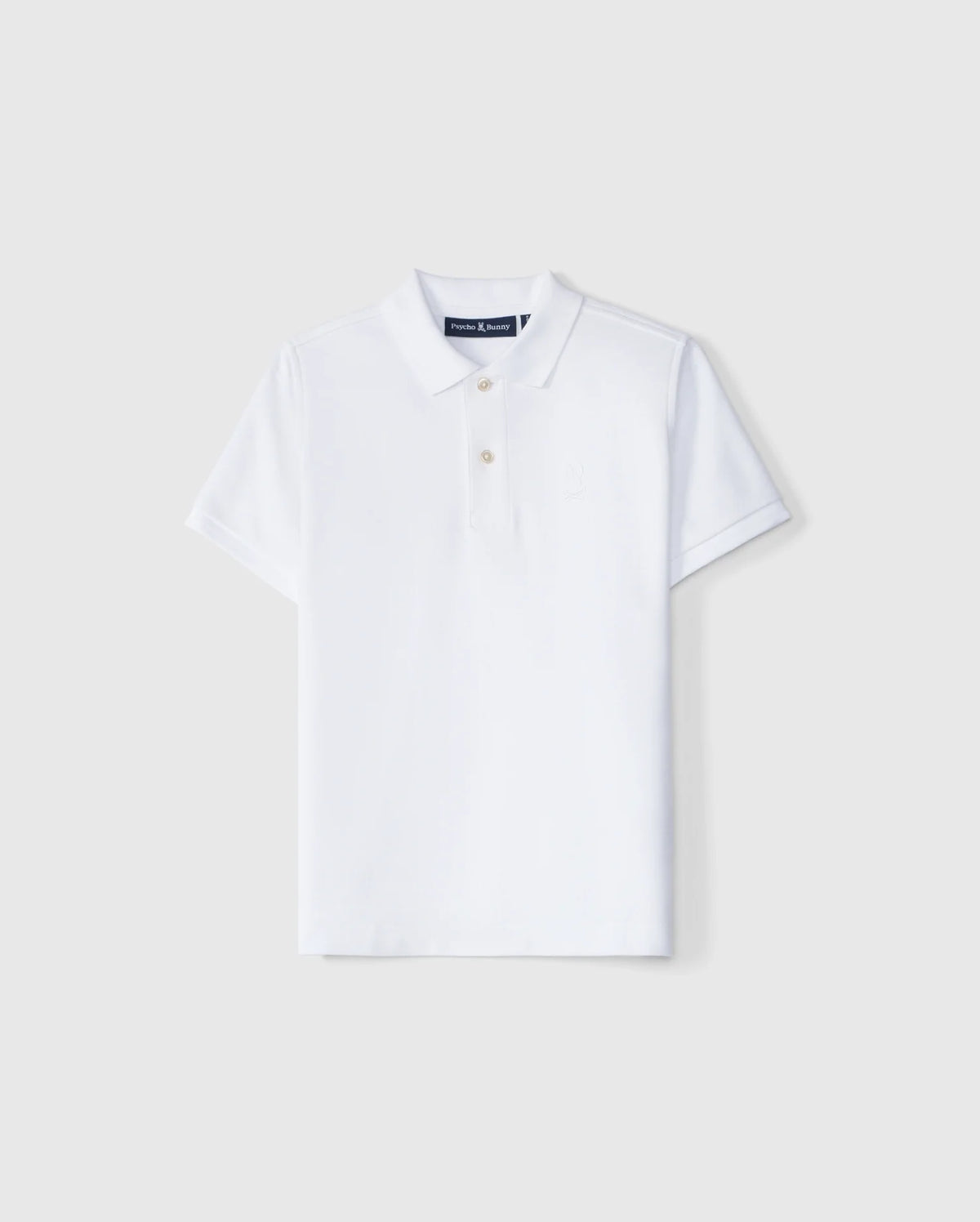 A Psycho Bunny Kids Classic Pique Polo Shirt (B0K021AR00) features a plain white design on a light gray background, crafted from luxurious Pima cotton. It has short sleeves, a classic collar, three white buttons, and an embroidered Bunny logo.