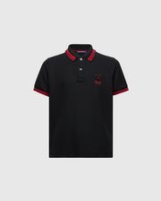 The KIDS PIERCE PIQUE POLO - B0K201E200 by Psycho Bunny is made from premium Pima cotton and features a timeless design with short sleeves. It includes red trim on the collar and sleeve hems, buttons near the collar, and an embroidered red bunny logo on the left chest.