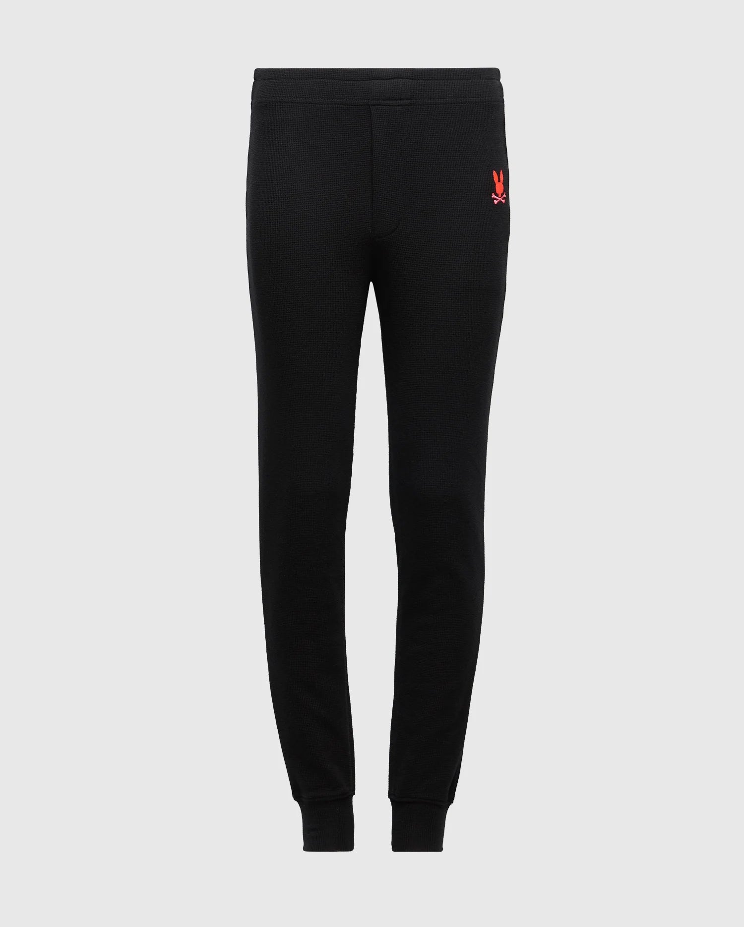 Introduce your kids to the perfect blend of comfort and style with the Psycho Bunny KIDS VAL WAFFLE PANT - B0P673E200. These black jogger pants, made from cozy waffle fabric, feature a small red embroidered design near the waist and come with elastic cuffs at the ankles. Their simple, streamlined design stands out beautifully against a plain light gray background, making them an ideal choice for children looking for both fashion and ease.