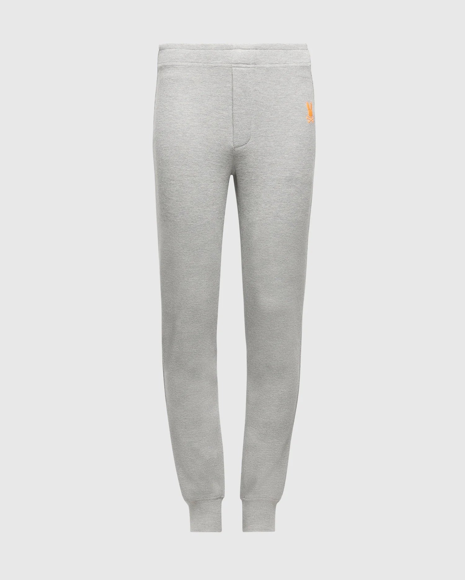 Psycho Bunny's KIDS VAL WAFFLE PANT (B0P673E200) in gray, made from soft Pima cotton and designed with elastic waistband and cuffs. These pants are adorned with a small orange embroidered logo on the upper left side, ideal for stylish lounging. The backdrop is a plain white setting.