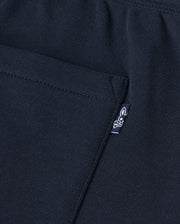 Close-up of a black Psycho Bunny Kids Lenox Sweatshort B0R377B200 in breathable fleece, featuring a pocket and small white logo tag with stylized animal figure on ribbed fabric—ideal for active kids.