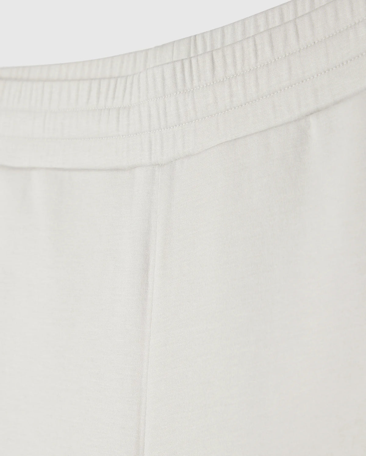 Close-up image of the upper part of a pair of Psycho Bunny KIDS LYONS SWEATSHORT - B0R578C200 showing the elastic waistband with gathered fabric. The soft stretch modal-cotton-blend jersey material appears smooth, indicating comfort and ease for everyday play. No additional details or design elements are visible.