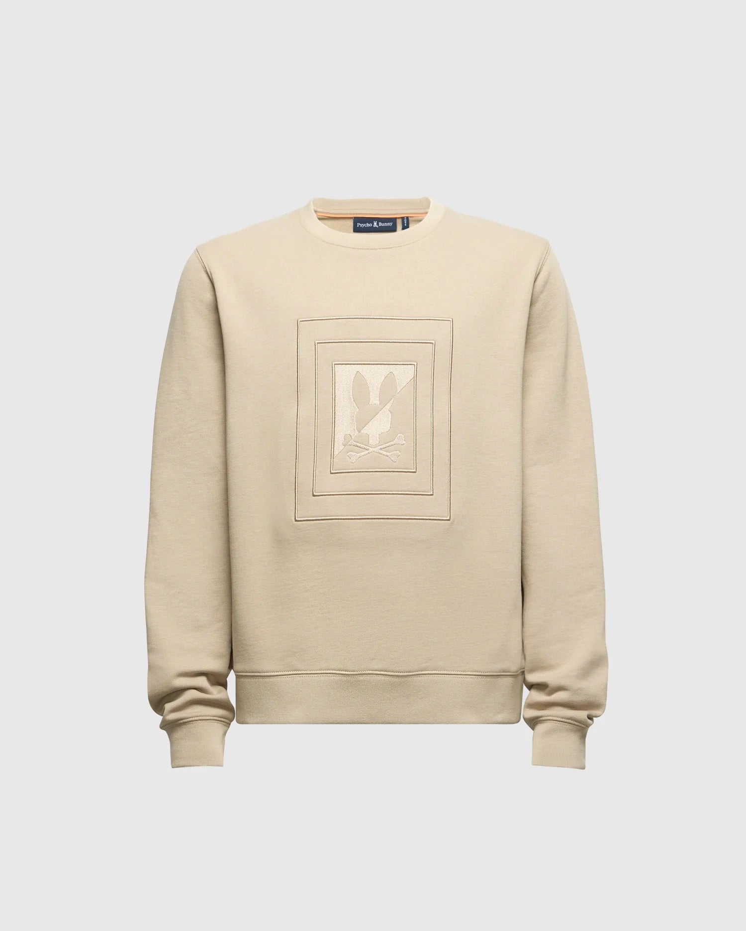 The KIDS OAK CITY CREW NECK SWEATSHIRT - B0S274E200 by Psycho Bunny is a beige, lightweight garment with long sleeves. It showcases an embossed rectangular design featuring a stylized rabbit against a plain light grey background, echoing the popular Psycho Bunny style. This piece is perfect for adding a charming touch to any child's wardrobe.