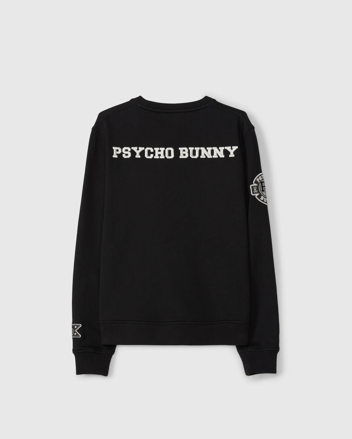 The KIDS ZACK VARSITY SWEATSHIRT - B0S880D200 by Psycho Bunny is a black varsity sweatshirt that prominently displays "Psycho Bunny" in bold white lettering on the back, accompanied by a vintage-inspired logo with chenille embroidery on the left sleeve.