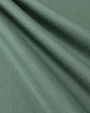 A close-up of folded Pima cotton fabric from the KIDS ALBERTON LONG SLEEVE TEE by Psycho Bunny, showcasing its smooth texture and subtle sheen. The fabric is draped in soft, diagonal folds, highlighting the material's flexibility and fine weave—perfect for creating a luxurious layering piece or a cozy long sleeve tee.