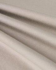 The close-up of the KIDS ALBERTON LONG SLEEVE TEE by Psycho Bunny reveals a beige textured fabric with soft folds and subtle horizontal lines. Made from Pima cotton, this material appears smooth and slightly reflective, creating gentle shadows and highlights across its surface.