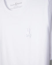 The KIDS EMBROIDERED CLASSIC TEE - B0U020AR00 from Psycho Bunny is a premium white t-shirt crafted from Peruvian Pima cotton, featuring the brand's intricate embroidered chest Bunny logo with detailed bunny and crossed bones below.
