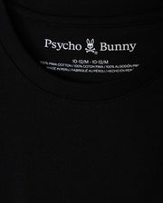 Close-up of a black KIDS HAWAII CITY TEE (B0U169Y1PC) by Psycho Bunny, crafted from Pima cotton with the brand name and bunny logo at the neckline. Includes size and fabric details, highlighting it's made in Peru, paralleling the volcanic islands' rich natural beauty.
