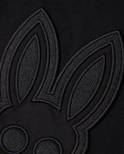 Close-up of a black fabric featuring an embroidered outline of a cartoon rabbit's face and ears, designed in a minimalist style with a monochromatic black-on-black color scheme. Showcasing Peruvian craftsmanship, the KIDS MALTON GRAPHIC TEE - B0U795D200 by Psycho Bunny is made from luxurious Pima cotton, adding texture and contrast.