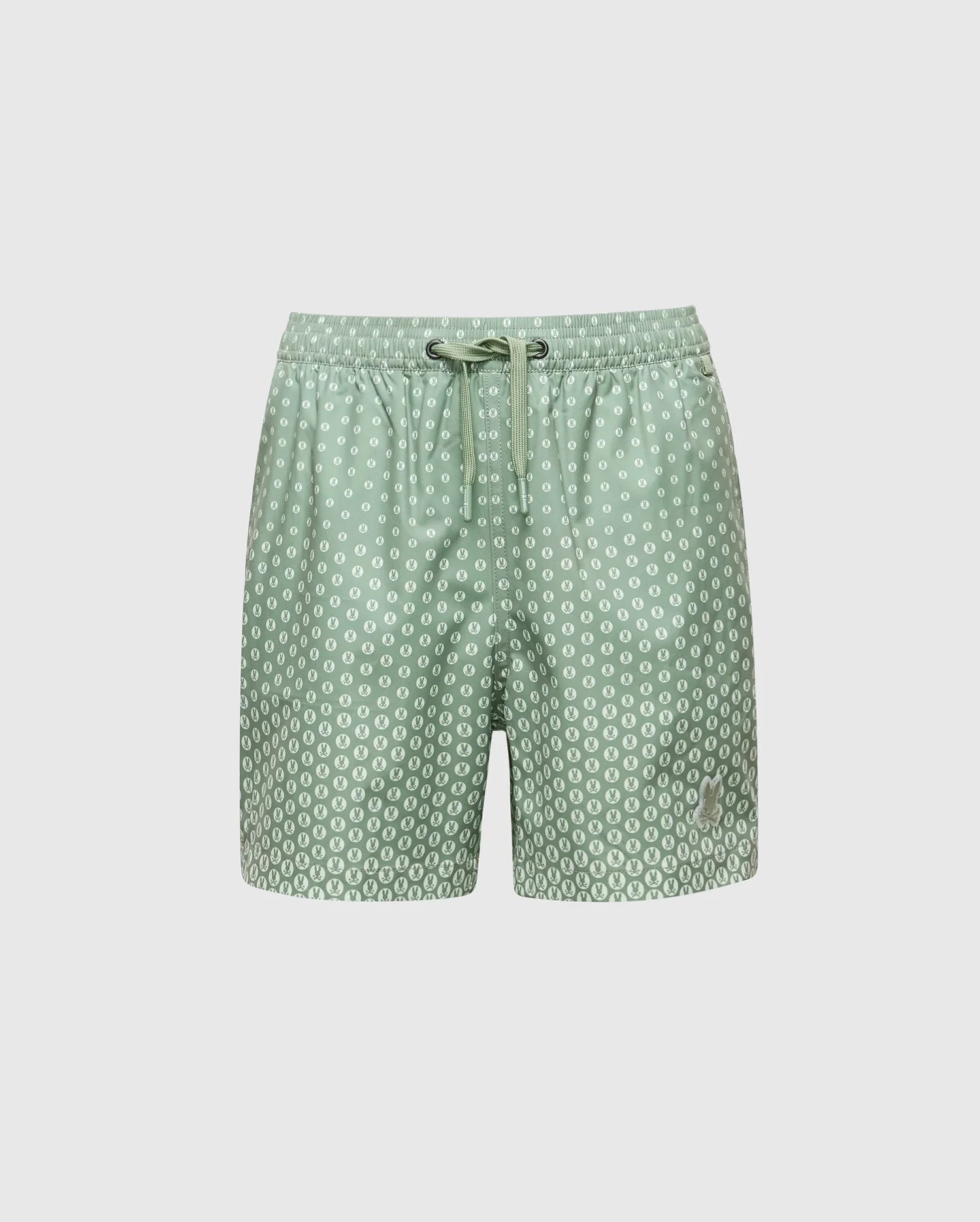 The KIDS BENDIGO PRINTED SWIM TRUNK - B0W619F200 by Psycho Bunny features light green swim shorts with white polka dots, crafted from quick-dry fabric. They have a drawstring waistband and are perfect for summer. Stored in a waterproof bag against a plain white background.