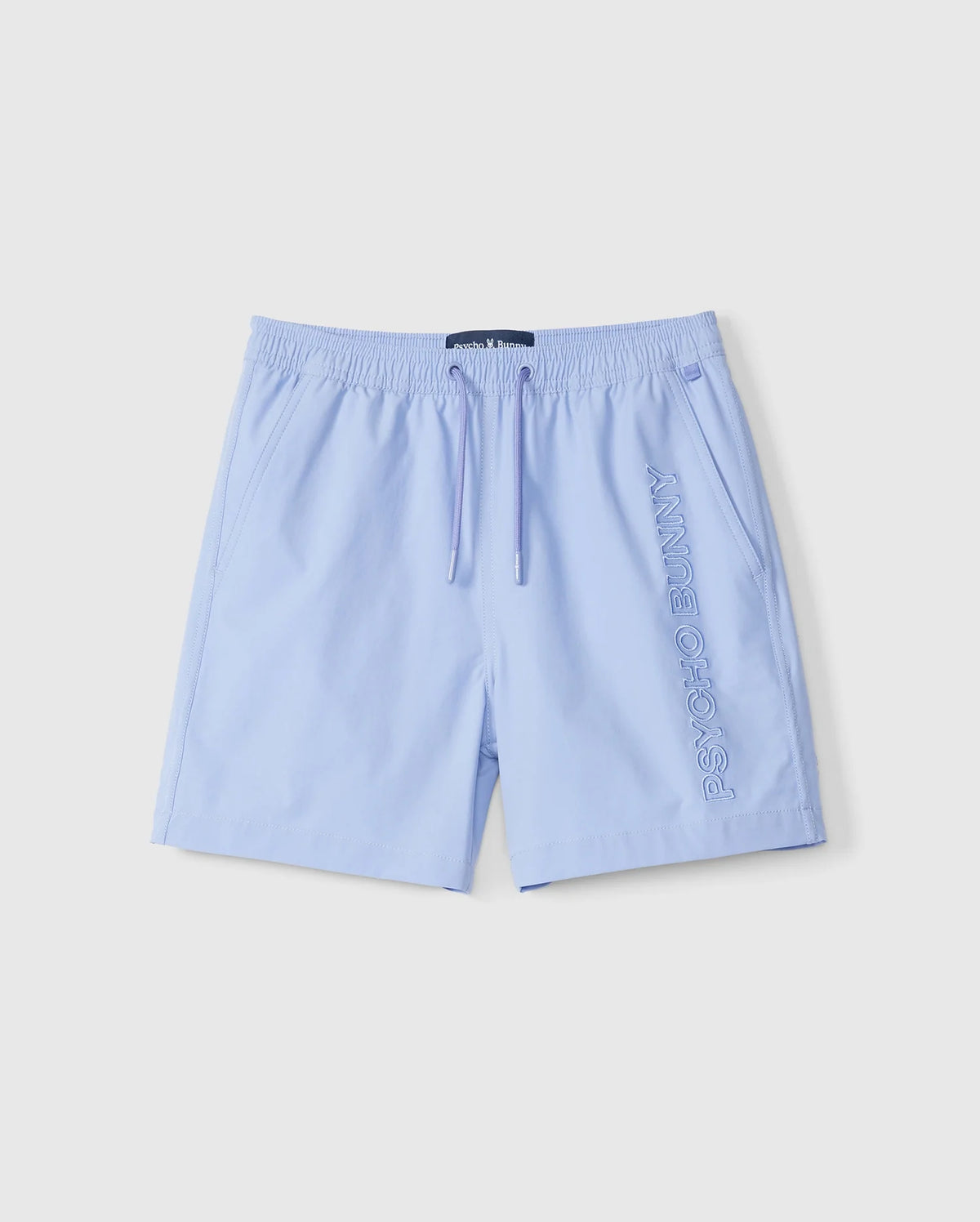 Light blue quick-dry KIDS MELVIN SWIM TRUNK by Psycho Bunny, featuring an elastic waistband and drawstring. The brand name is embroidered vertically on the left leg. Suitable for leisure or sports, these casual swim trunks provide comfort and functionality.