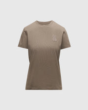 Introducing the WOMENS ALEXANDER GRAPHIC TEE by Psycho Bunny, a classic plain brown tee made from luxurious Pima cotton. It showcases a subtle Lurex embroidered bunny logo on the upper left side. Designed with a round neckline and short sleeves, this piece offers comfort and style with its light grey backdrop.