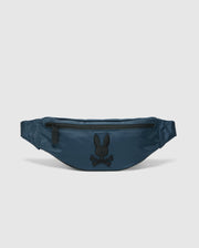 The Psycho Bunny MENS CROSS BODY BAG - B6A181E200, crafted from blue nylon, features a black zipper and an embroidered rabbit head logo above crossed bones in black on the front, making it the perfect functional waist bag for men.