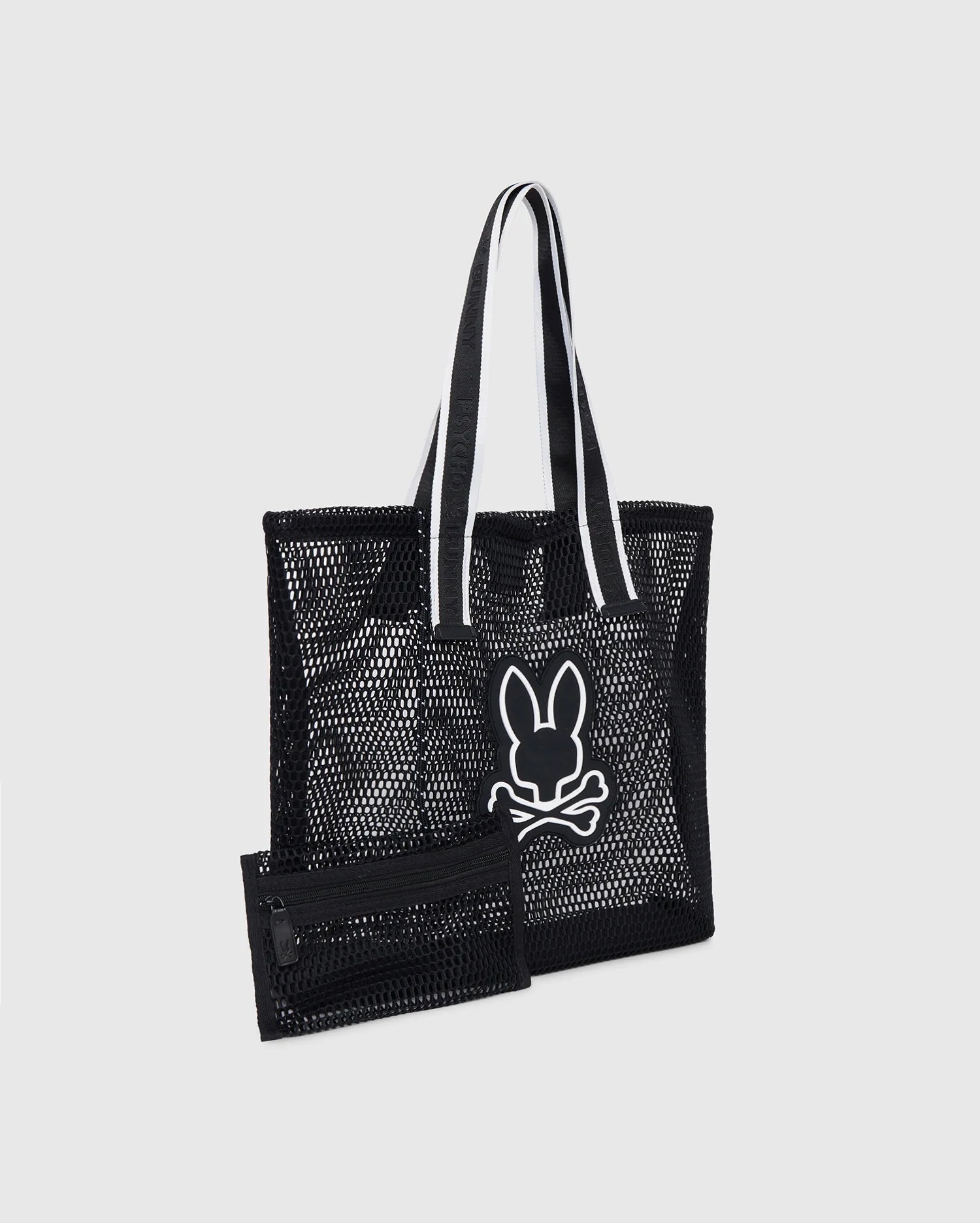 A black Psycho Bunny MENS MESH TOTE BAG - B6A388B200 with logo-webbing straps featuring a white outlined graphic of a rabbit head and crossed bones. Accompanied by a detachable zip pouch in matching black mesh with a zipper. The handles have white inner lining for contrast, set against a plain gray background.