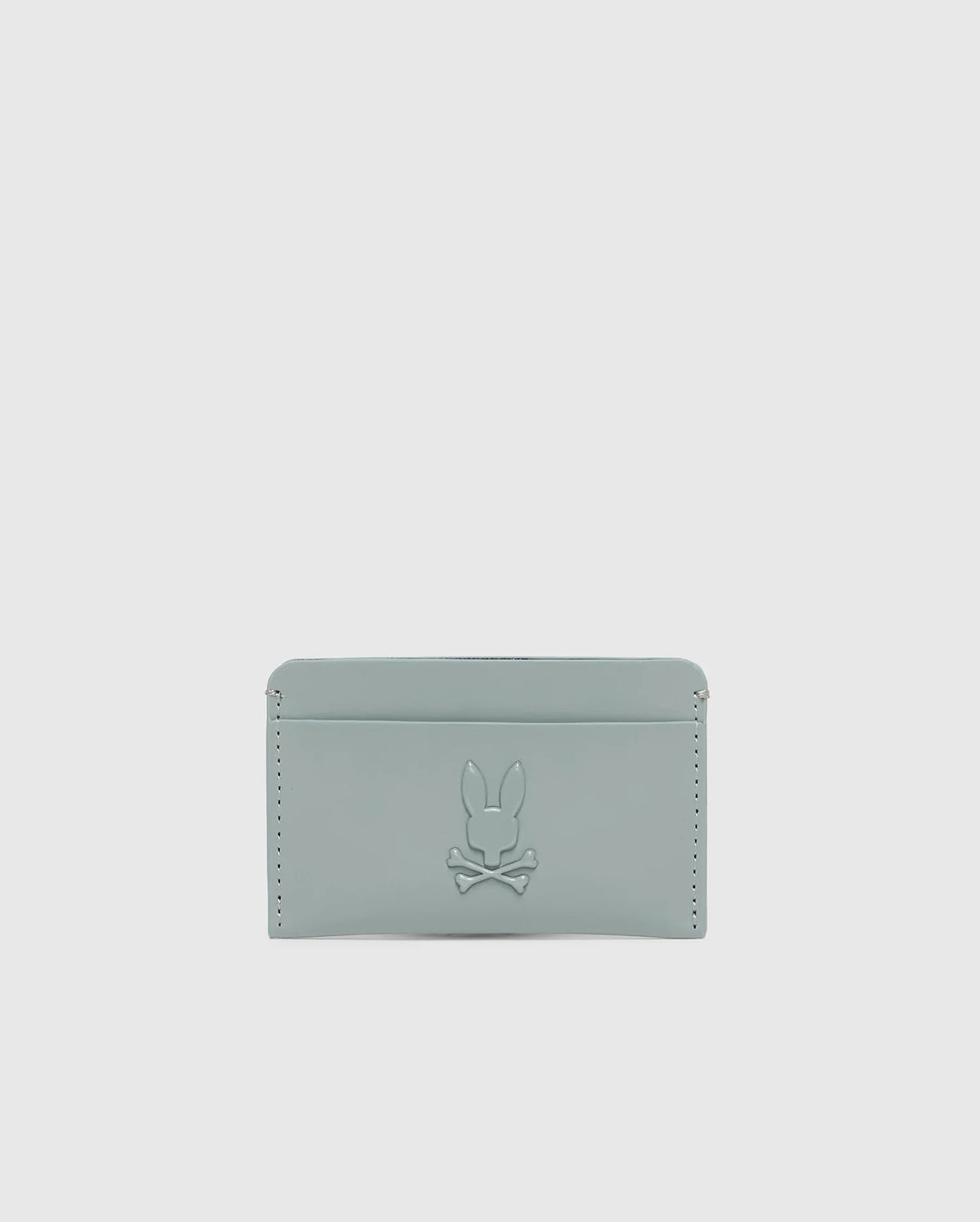 The "MENS RUBBERIZED CARD CASE - B6A473F200" by Psycho Bunny is a minimalist, light gray wallet featuring a subtle rabbit and crossbones embossment and edge stitch details for secure storage.