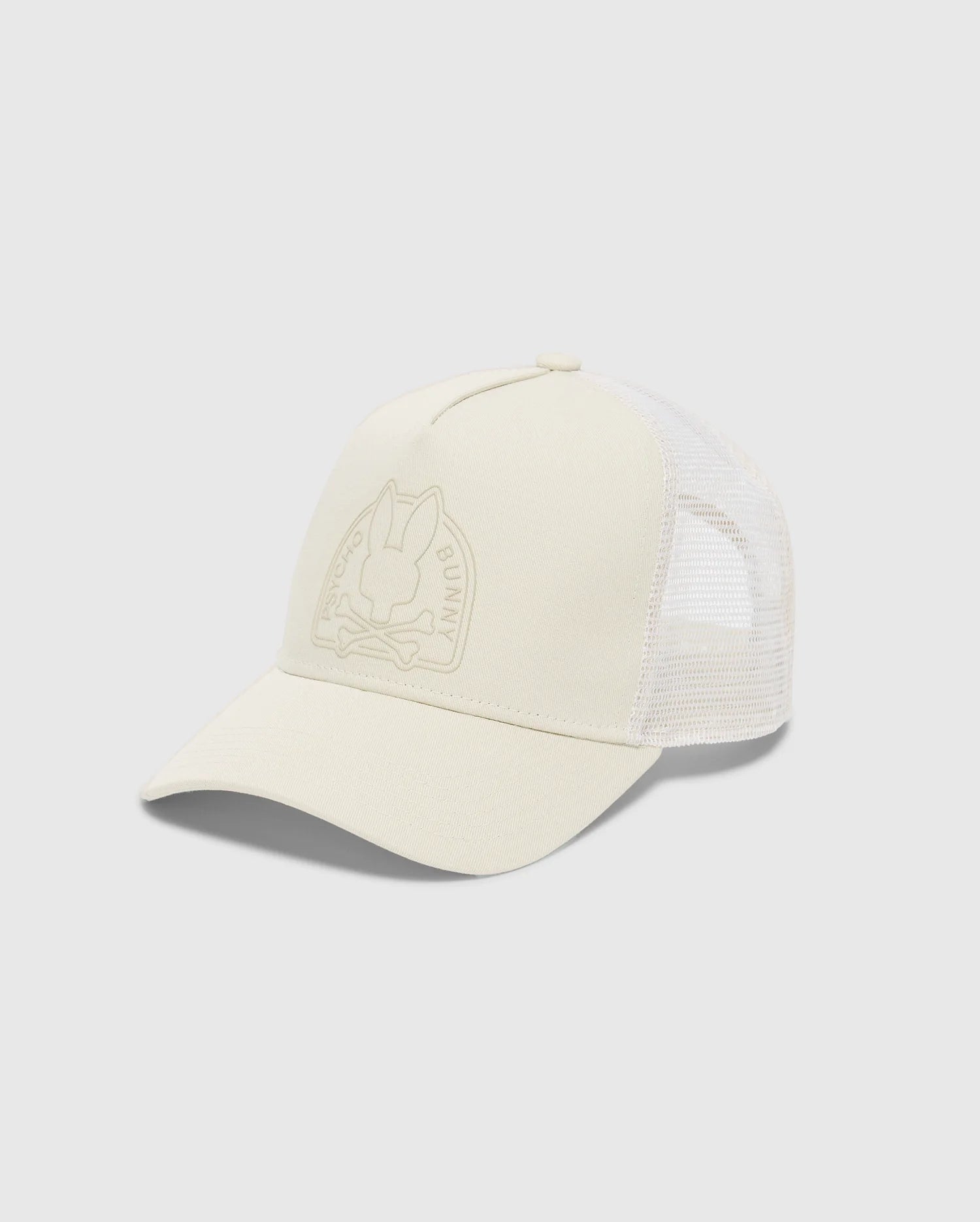 The MENS MELBOURNE GRAPHIC TRUCKER HAT by Psycho Bunny is light beige with a mesh back and curved brim. It features a subtle embossed bunny and crossbones on the front, complemented by an adjustable snap-back strap for the perfect fit.
