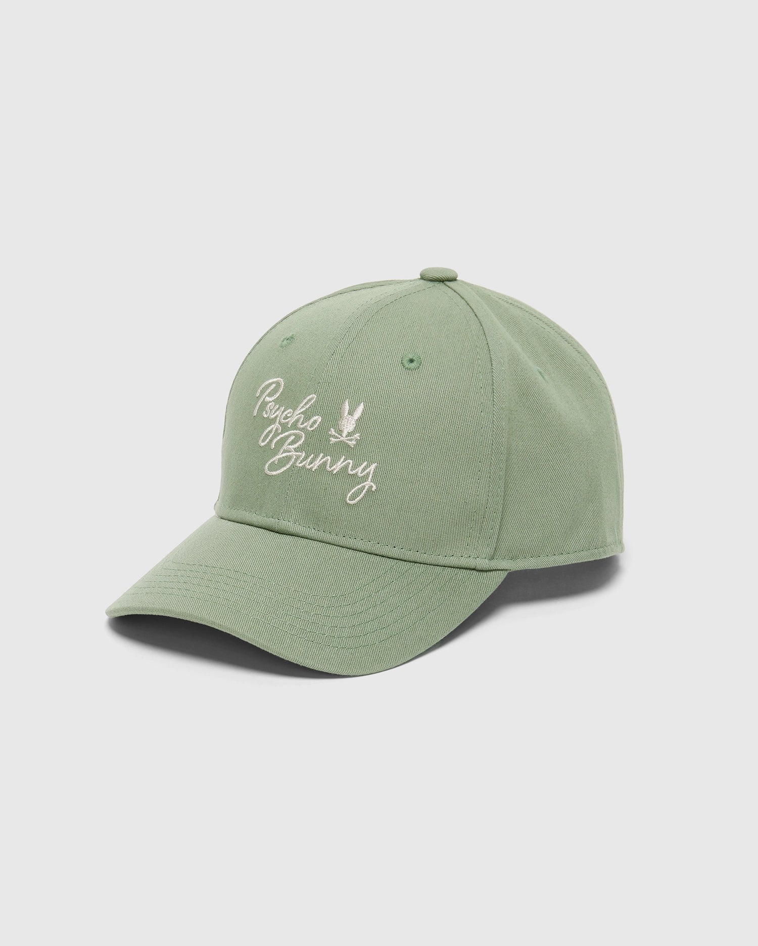 The MENS DESERT BASEBALL CAP - B6A549F200 by Psycho Bunny is a green hat with an embroidered white "Psycho Bunny" wordmark. It has six panels, a curved brim, and an adjustable strap for the perfect fit.