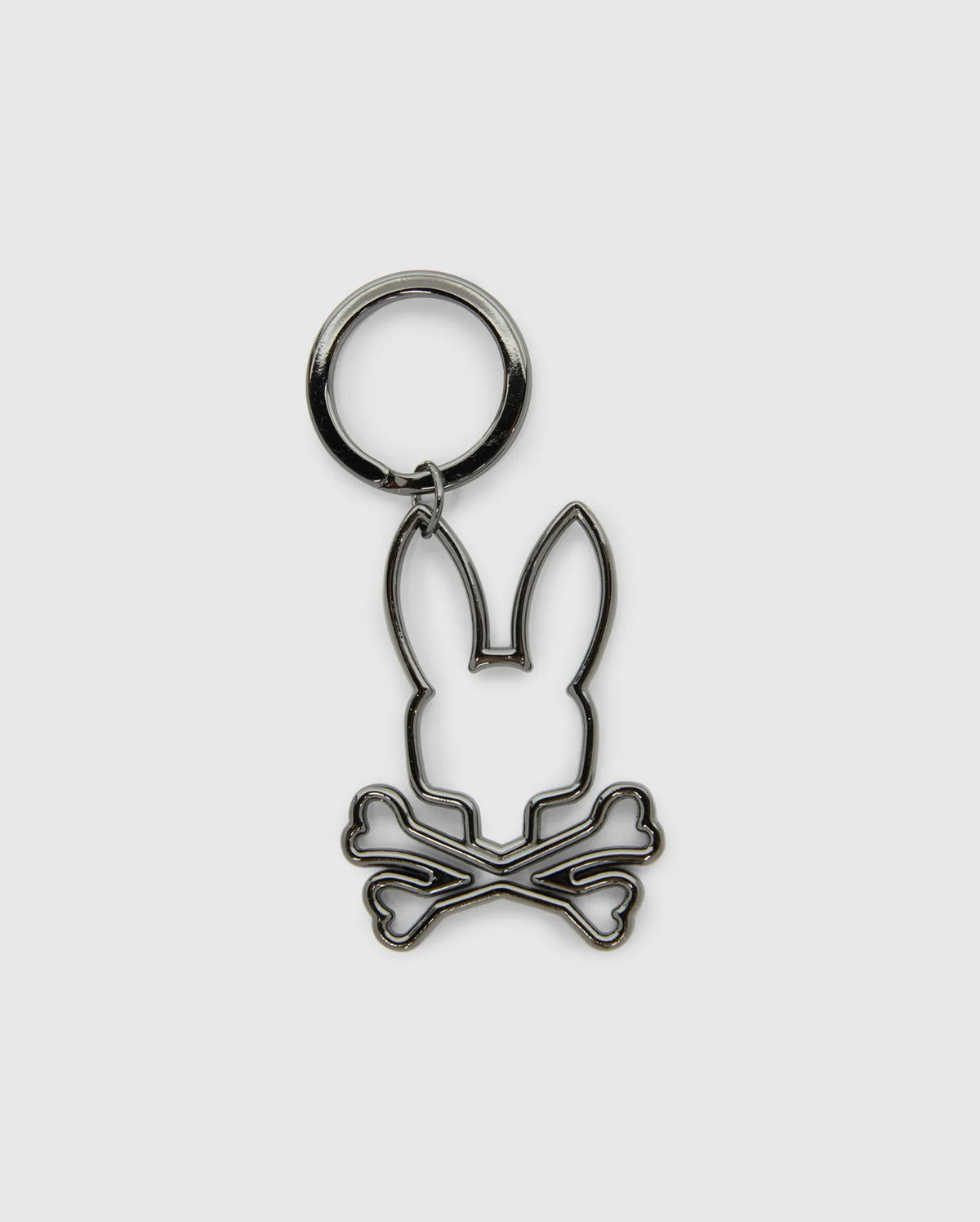 This trendy OUTLINE BUNNY KEYCHAIN - B6A565E200 from Psycho Bunny showcases a cartoon bunny head above crossed bones in a sleek metallic outline. It features an elegant gold-plated keyring at the top and stands out against a plain light gray background, making it a stylish accessory.