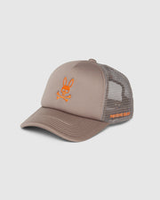 The MENS PARIS TRUCKER CAP - B6A591C200 by Psycho Bunny is a grey cap with a mesh back and solid front. It features an embroidered orange bunny logo resembling a skull and crossbones on the front, and "G/FORE" text in orange on the side.