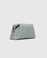 The Psycho Bunny MENS TOILETRY KIT - B6A636F200 is a minimalist light gray polyester pouch, ideal for organizing essentials on the go. It features a zippered top and an embossed bunny and crossbones design on the side, enhancing its sleek and modern look against the plain gray background.