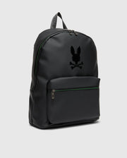 The MENS RUBBERIZED BACKPACK - B6A637F200 by Psycho Bunny features a minimalist black design with a front zippered pocket. It showcases a stylized rabbit with crossbones logo on the front, crafted from smooth material for durability, and sleek zippers against a plain gray background.