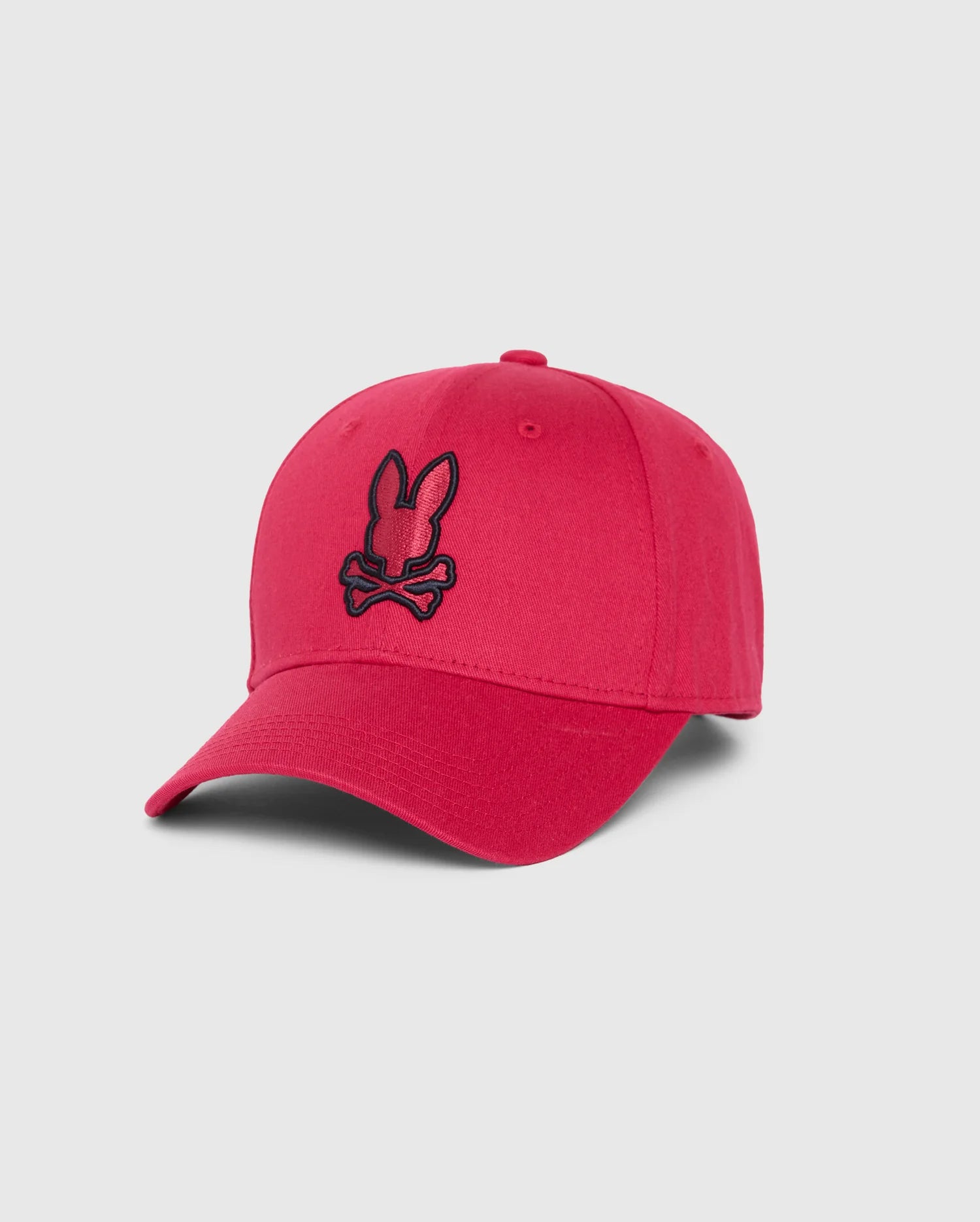The MENS WALTER BASEBALL CAP - B6A800D200 by Psycho Bunny is made from 100% cotton and features a red design with a black embroidered logo depicting bunny ears above crossbones on the front. It has a curved brim and is designed for durability and comfort, making it an excellent choice for everyday wear, all set against a plain background.