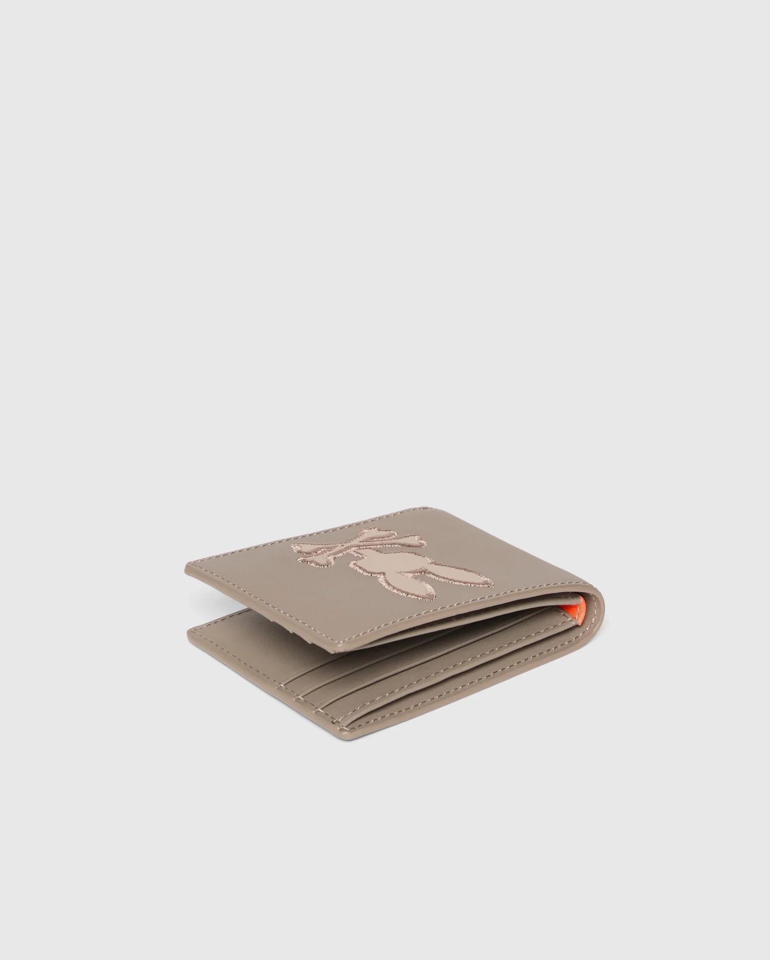The MENS LEATHER WALLET - B6A868D200 by Psycho Bunny is a high-quality beige leather wallet with intricate floral embroidery, revealing a matching interior with multiple card slots, embodying elegance and function against a white background.