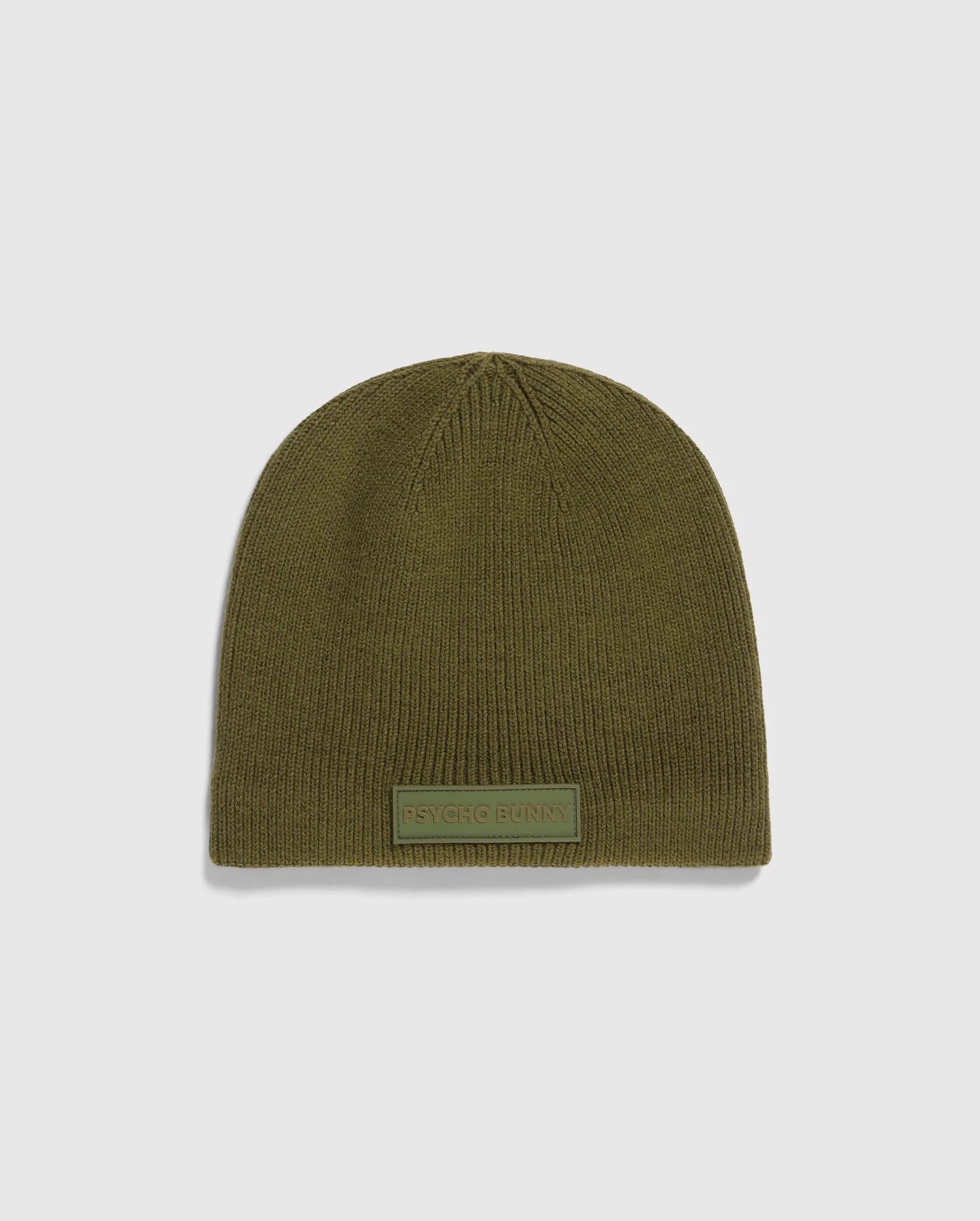 The MENS SPORT BEANIE - B6A874D200 by Psycho Bunny is a premium olive green knitted hat made from merino wool, featuring a small rectangular "Psycho Bunny" patch on the front. It is showcased against a light gray background, emphasizing its high-performance quality.