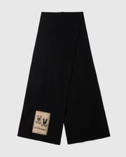 The Psycho Bunny MENS MONROE TWILL PATCH SCARF - B6A892D200, crafted from a luxurious black cotton wool blend and adorned with a beige patch showcasing two bunny silhouettes, is elegantly displayed on a light gray background.