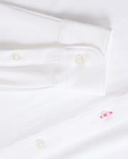 Get a closer look at the timeless MENS ARTHUR JERSEY SHIRT - B6C748D200 from Psycho Bunny, made from smooth stretch Pima cotton. It showcases a sleeve cuff with two white buttons and a distinctive pink button on the shirt front.