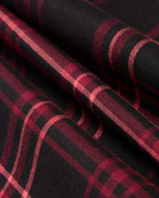 Close-up of a folded MENS HAYES PLAID SHIRT - B6C842D200 by Psycho Bunny, featuring a red and black checkered pattern crafted from luxurious Pima cotton. The intersecting horizontal and vertical lines showcase the classic design typical of a quality button-down shirt.