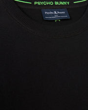 Close-up of the MENS BELMORE EXTRA FINE COTTON SWEATER - B6E832D200 by Psycho Bunny in black, highlighting its texture. The label inside displays "Psycho Bunny," with premium stitching and contrasting green thread embellishing the neckline. The tonal embroidered Bunny logo adds a subtle yet sophisticated touch.