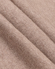 The image features a close-up of the MENS BRADSHAW POLO SWEATER - B6E835D200 by Psycho Bunny, showcasing its soft brown fabric with a diagonal seam. The textile's texture reveals a subtle woven pattern, reminiscent of luxury garments and ideal for clothing or upholstery, giving it a cozy and warm appearance.