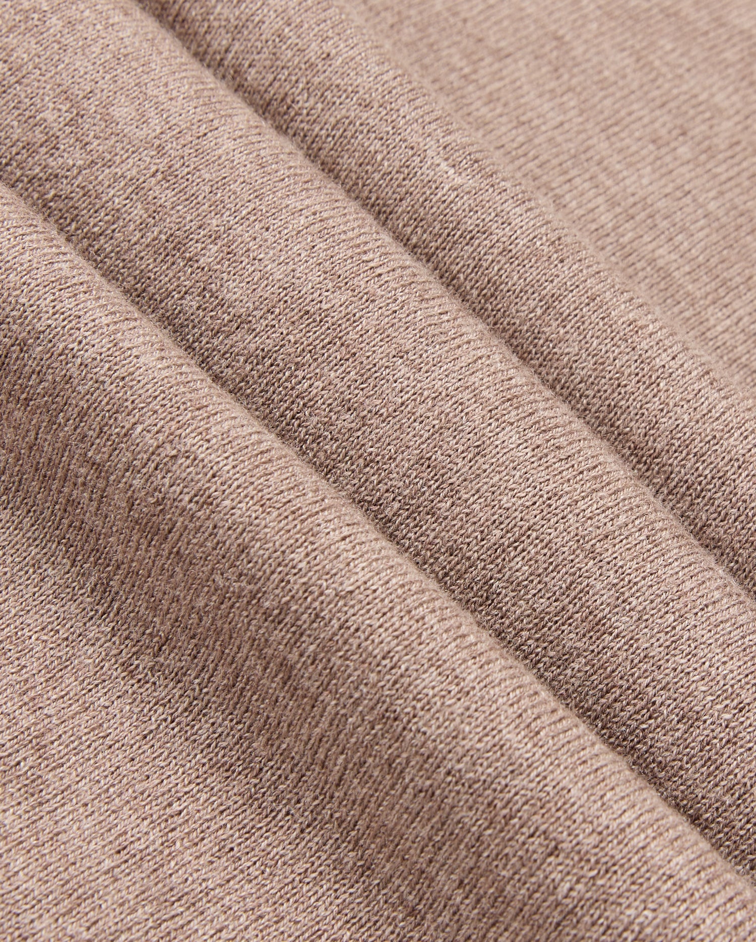 The image features a close-up of the MENS BRADSHAW POLO SWEATER - B6E835D200 by Psycho Bunny, showcasing its soft brown fabric with a diagonal seam. The textile's texture reveals a subtle woven pattern, reminiscent of luxury garments and ideal for clothing or upholstery, giving it a cozy and warm appearance.
