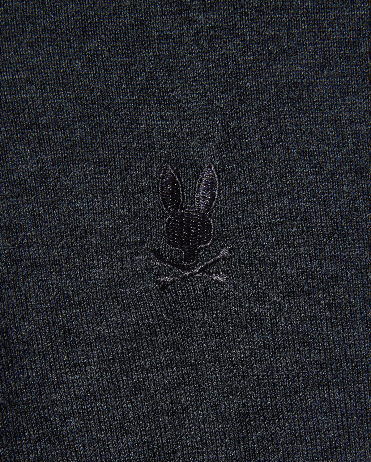 The MENS BRADSHAW POLO SWEATER - B6E835D200 from Psycho Bunny is made from premium merino wool and features a subtle design of a rabbit head with crossed bones, echoing the traditional skull and crossbones motif.