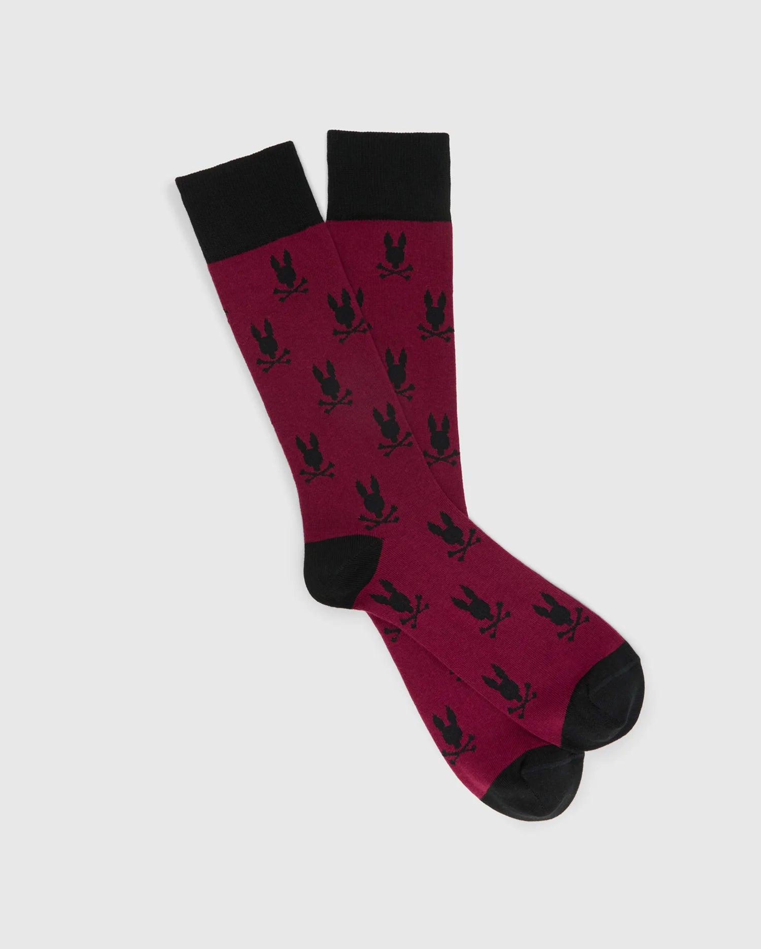 The MENS ALL OVER BUNNY DRESS SOCK by Psycho Bunny is expertly crafted from soft Pima cotton, featuring a maroon shade accented with black trim at the top, heels, and toes. This stylish design highlights a striking pattern of black bunny silhouettes.