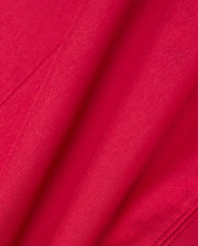 A close-up of the vibrant red fabric from the Psycho Bunny MENS WALTER LIGHTWEIGHT HOODIE - B6H476D200 highlights its smooth texture and gentle folds, evoking an elegance reminiscent of delicate craftsmanship.