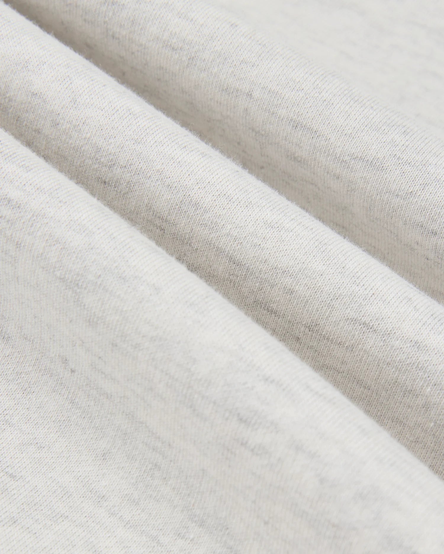 Close-up image of the Psycho Bunny MENS JAMES PREMIUM HOODIE - B6H789D200, highlighting its premium jersey fabric with a soft texture, gentle folds, and subtle gray speckles. The material looks lightweight and comfortable, promising a touch of stylish warmth.