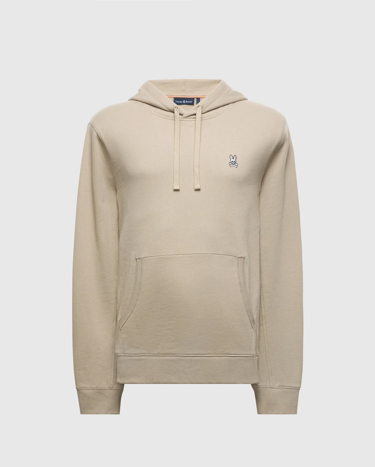 The MENS LEVY ESSENTIAL FLEECE HOODIE by Psycho Bunny is a beige cotton hoodie designed for men, featuring a front pocket and drawstring hood. It showcases a small, embroidered bunny logo with crossed eyes on the left chest. The fleece hoodie is set against a light gray background.
