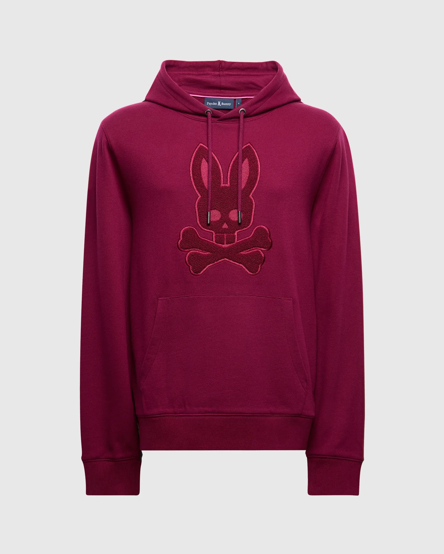 The Psycho Bunny MENS PACIFIC HIGH PILE CHENILLE HOODIE - B6H930D200, crafted in luxurious cotton with a rich maroon color, features an embroidered bunny with crossed bones on the front. This hoodie includes a convenient kangaroo pocket and a hood equipped with drawstrings, beautifully set against a plain white background.