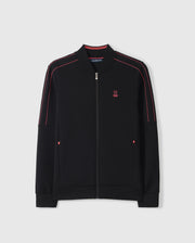The Psycho Bunny MENS TRAVIS TRACK JACKET - B6J142D200 is a sleek black zip-up that boasts striking red piping along the shoulders and sleeves. It features a small red embroidered bunny logo on the left chest and two front invisible zip pockets with red accents. The plain, light gray background of the jacket makes it ideal for seamless transitions from training to recovery.