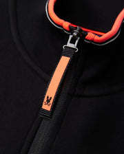 Close-up image of a black Psycho Bunny MENS COURTSIDE TRACK JACKET - B6J692C200 made from stretch cotton-blend jersey, featuring a bright orange zipper pull with a small skull and crossbones detail. The inner edge of the collar is also lined with bright orange, adding a pop of color to the garment.