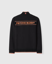 A black MENS COURTSIDE TRACK JACKET - B6J692C200 displayed from the back with the words "PSYCHO BUNNY" in large orange letters across the upper back. The collar has a small orange emblem, and thin orange lines trim the collar, cuffs, and hem. Crafted from stretch cotton-blend jersey for added comfort by Psycho Bunny.
