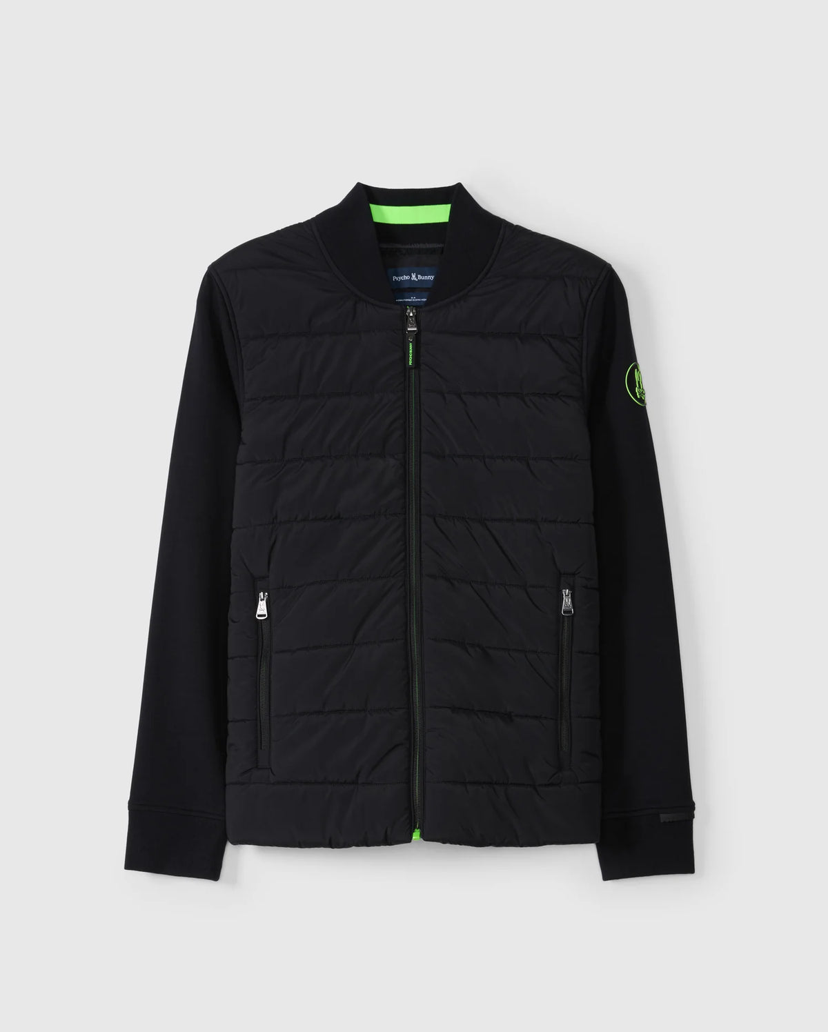 Introducing the MENS MYKEL MIXED MEDIA JACKET - B6J875D200 by Psycho Bunny. This versatile black jacket combines a quilted front with solid sleeves and includes a convenient front zipper along with two zippered pockets. Featuring a circular logo patch on the left sleeve, this stylish men's jacket is beautifully showcased against a light gray background.