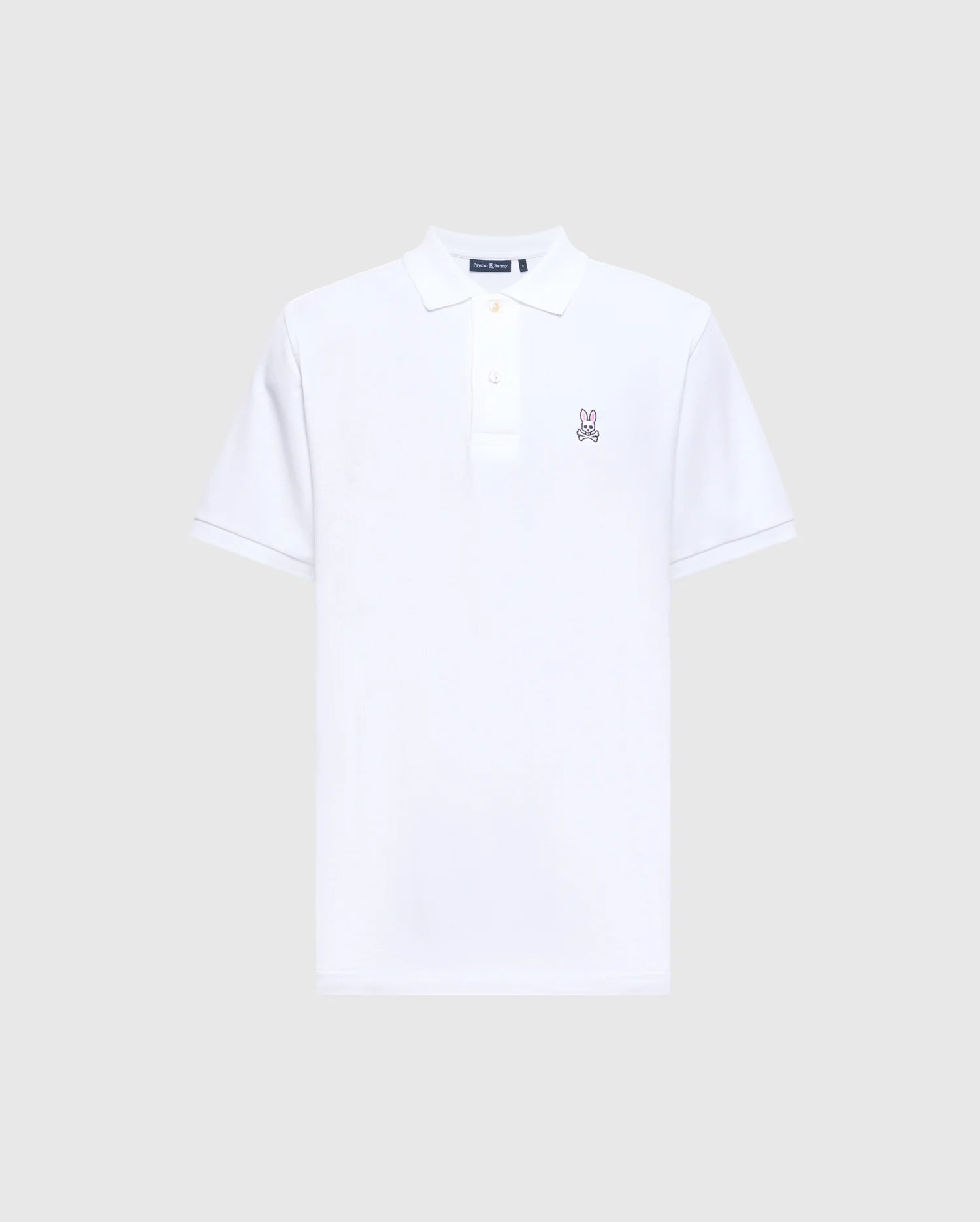 This Psycho Bunny Men's Classic Pique Polo Shirt (B6K001ARPC) is crafted from 100% Pima cotton in plain white, featuring a collar and short sleeves. It boasts a three-button placket with mother-of-pearl buttons and an embroidered small rabbit logo on the left chest, set against a light grey background.
